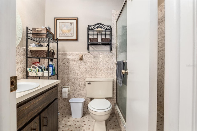 bathroom featuring tile patterned floors, an enclosed shower, vanity, tile walls, and toilet