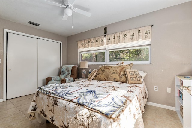 bedroom with ceiling fan, a closet, and light tile patterned floors