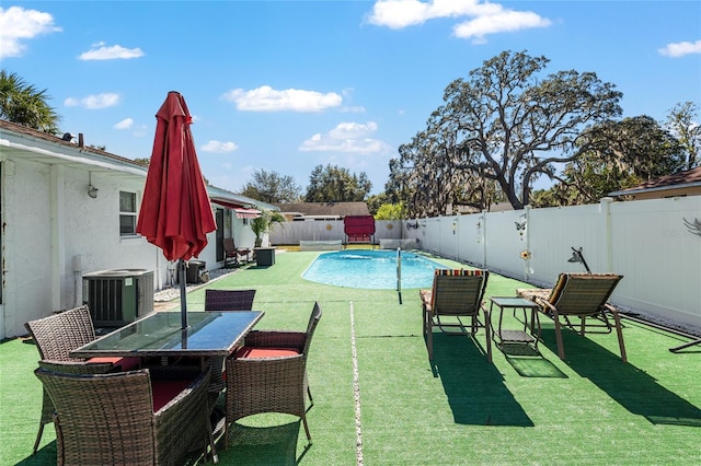 view of swimming pool with a lawn and cooling unit