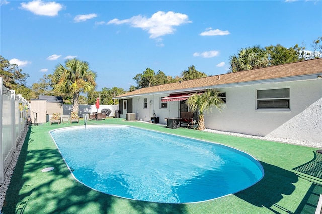 view of pool with central air condition unit and a storage shed