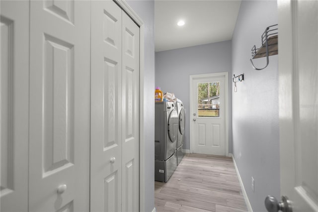 laundry room with washer and dryer and light hardwood / wood-style floors