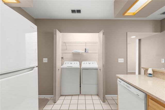 washroom with separate washer and dryer and light tile patterned flooring