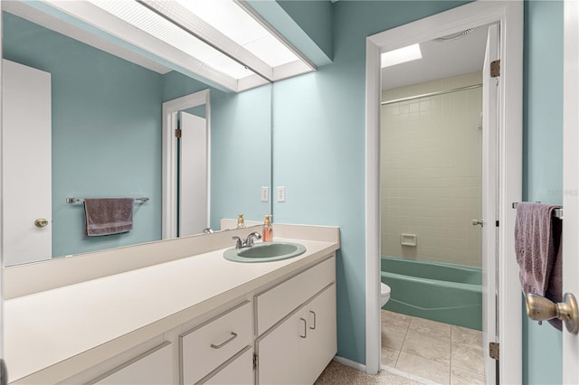 full bathroom with tile patterned floors, vanity, toilet, and tiled shower / bath combo