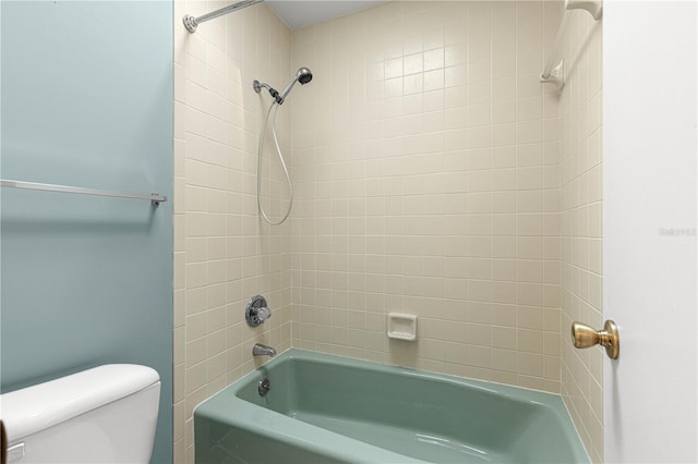 bathroom with tiled shower / bath combo and toilet