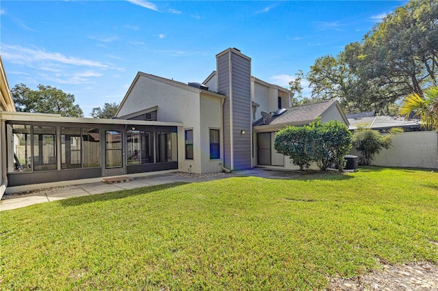 rear view of house featuring a sunroom, central AC unit, and a yard