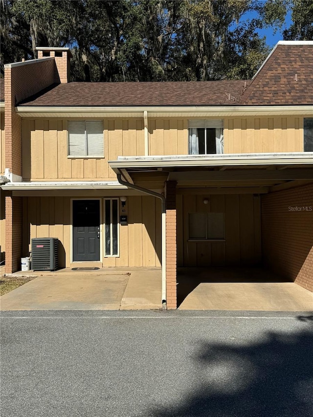 view of front facade featuring central AC and a carport