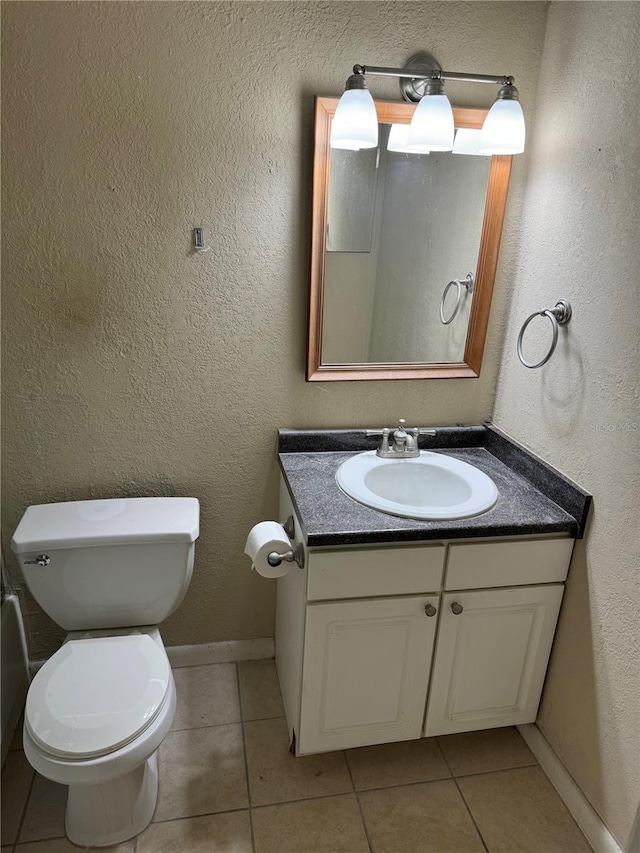 bathroom featuring tile patterned flooring, vanity, and toilet