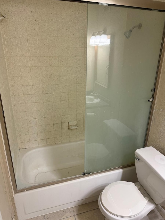 bathroom with tile patterned floors, enclosed tub / shower combo, and toilet