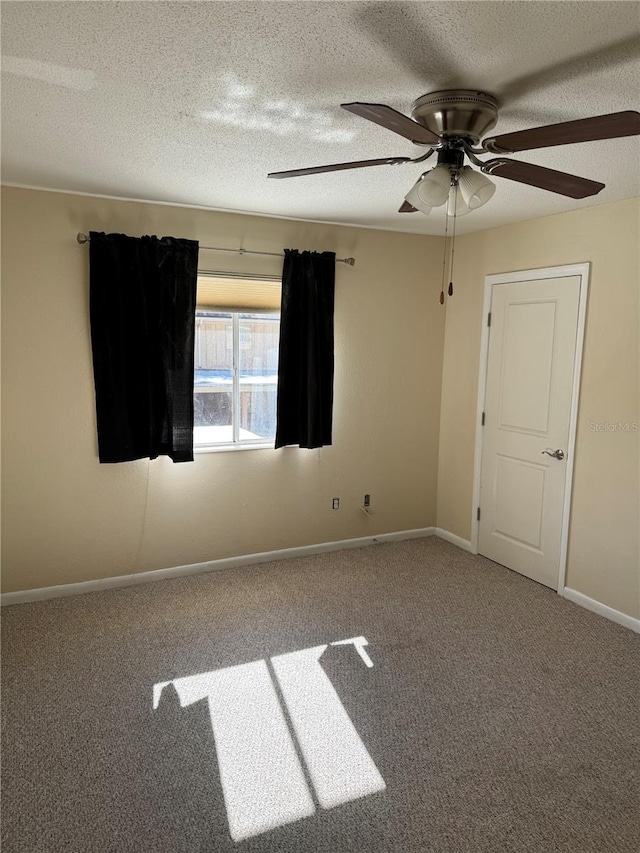 carpeted spare room with a textured ceiling and ceiling fan