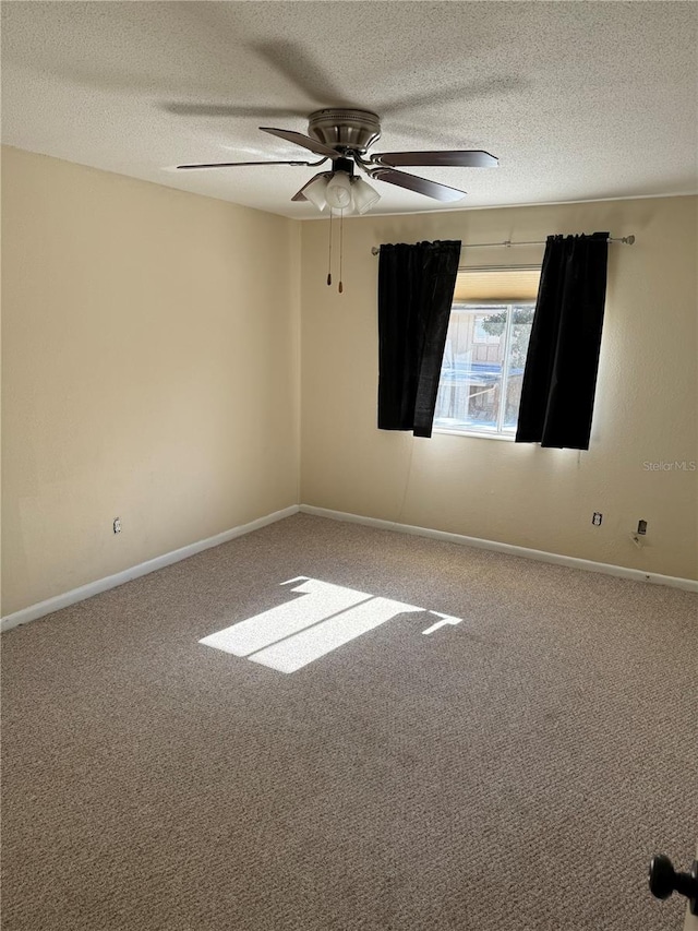 carpeted empty room featuring ceiling fan and a textured ceiling