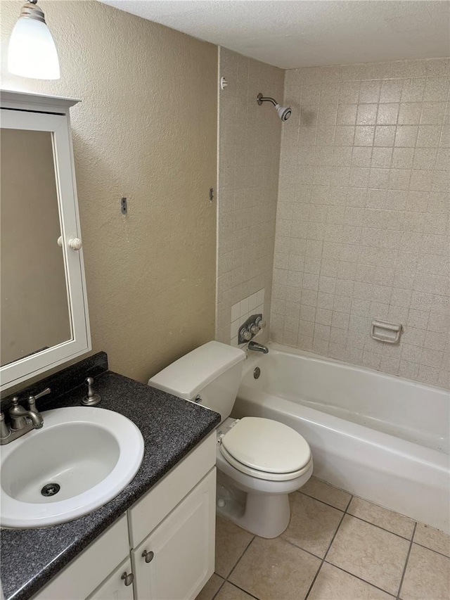 full bathroom featuring vanity, tile patterned flooring, tiled shower / bath combo, toilet, and a textured ceiling