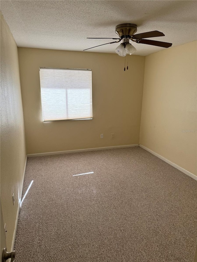 carpeted spare room featuring ceiling fan and a textured ceiling