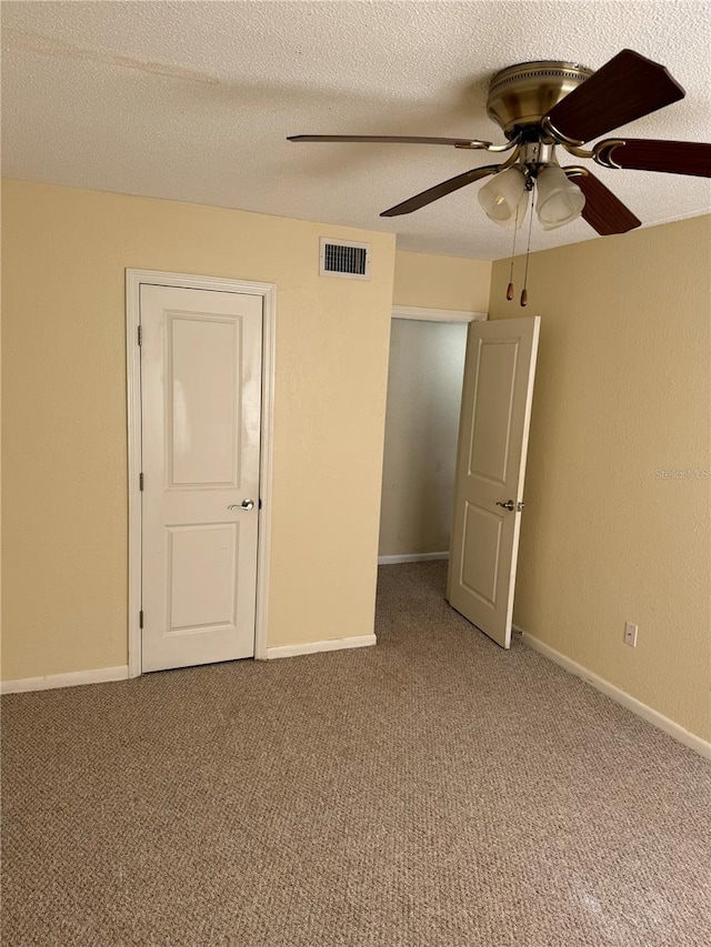 carpeted empty room with a textured ceiling and ceiling fan