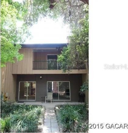 rear view of property featuring a patio area and a balcony