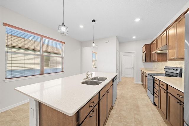 kitchen with stainless steel appliances, sink, decorative light fixtures, a center island with sink, and light tile patterned flooring