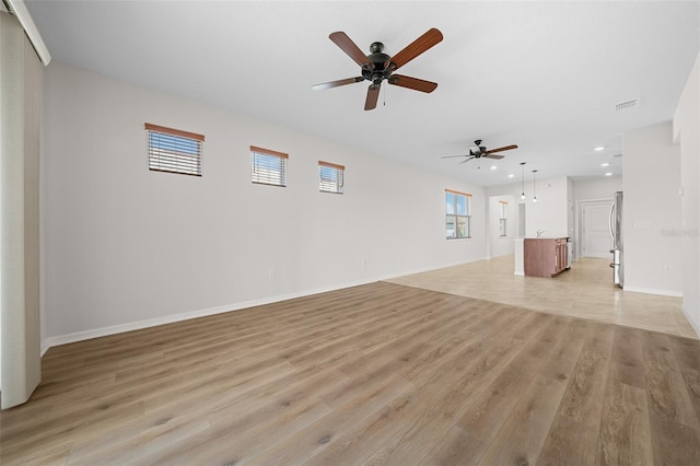 unfurnished living room featuring ceiling fan and light hardwood / wood-style floors