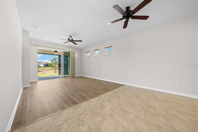 unfurnished room featuring ceiling fan, light hardwood / wood-style flooring, and a textured ceiling