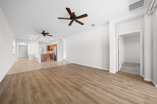 unfurnished living room with ceiling fan and light hardwood / wood-style floors