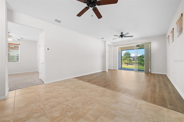 spare room featuring ceiling fan, light wood-type flooring, and a wealth of natural light