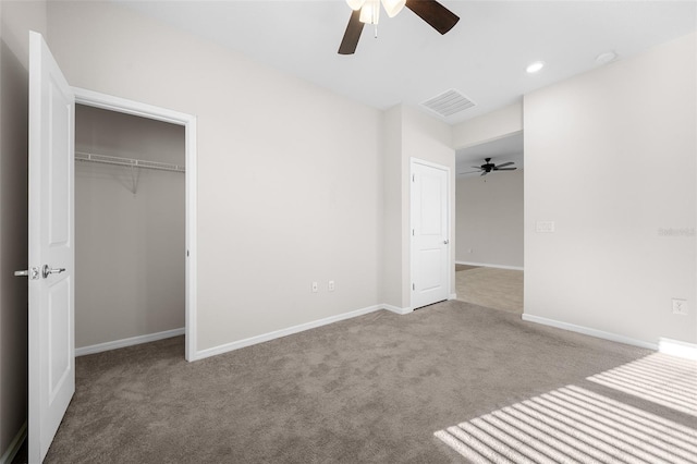 unfurnished bedroom with ceiling fan, a closet, and light carpet