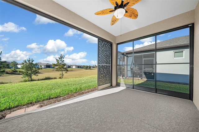 unfurnished sunroom with ceiling fan