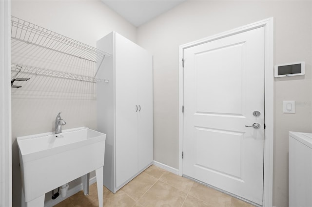 laundry room featuring light tile patterned flooring and sink