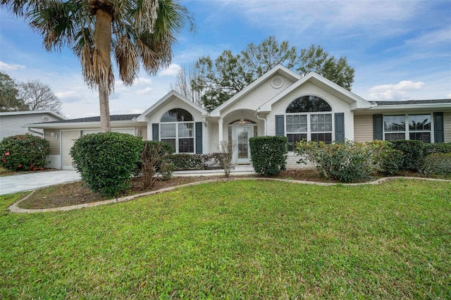 ranch-style house featuring an attached garage, driveway, and a front yard