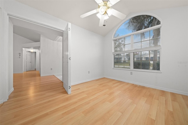 unfurnished room with lofted ceiling, ceiling fan, light wood-style flooring, and baseboards