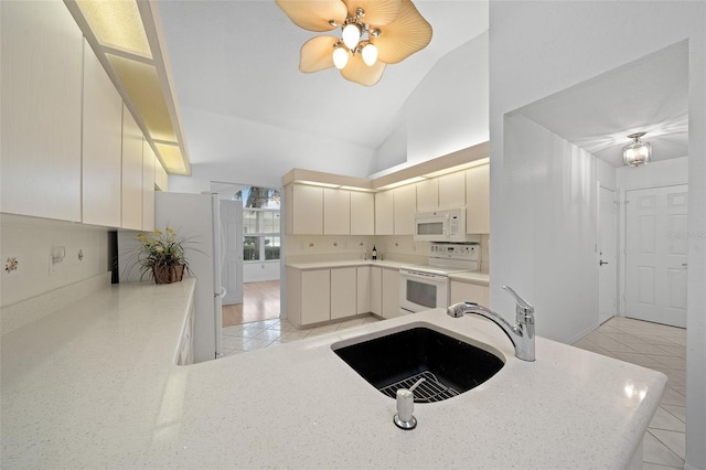 kitchen with white appliances, modern cabinets, a peninsula, light countertops, and a sink