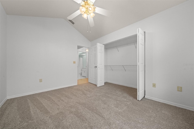 unfurnished bedroom featuring lofted ceiling, a closet, light carpet, and baseboards