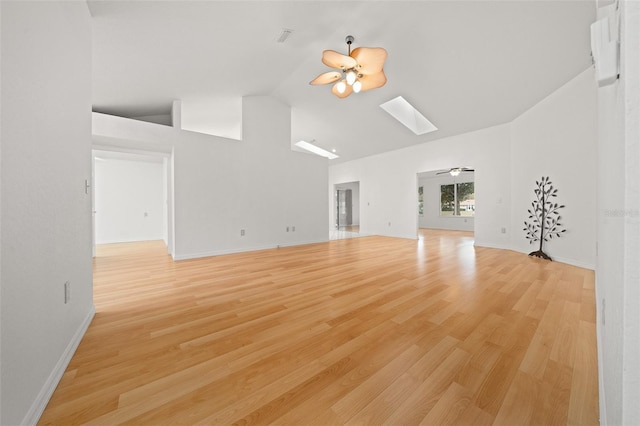 unfurnished living room with a skylight, ceiling fan, high vaulted ceiling, and light wood finished floors