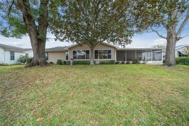 view of front facade with a front yard and a sunroom