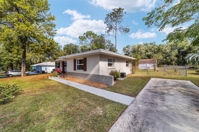 single story home featuring a front lawn and central air condition unit