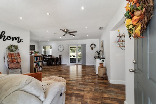 living room featuring ceiling fan and dark hardwood / wood-style floors