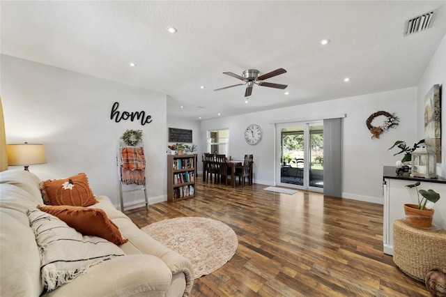 living room with ceiling fan and dark hardwood / wood-style flooring