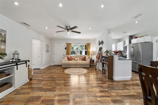 living room with ceiling fan and dark hardwood / wood-style floors