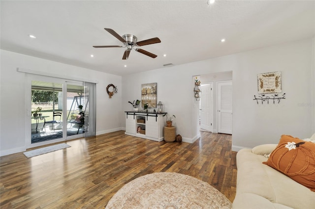 living room with dark hardwood / wood-style floors and ceiling fan