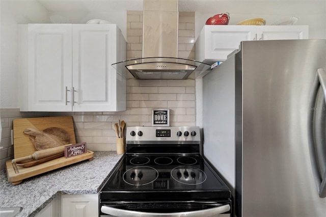 kitchen with light stone countertops, appliances with stainless steel finishes, tasteful backsplash, wall chimney exhaust hood, and white cabinetry