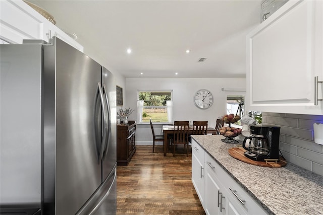 kitchen featuring white cabinetry, a wealth of natural light, stainless steel fridge, and light stone countertops