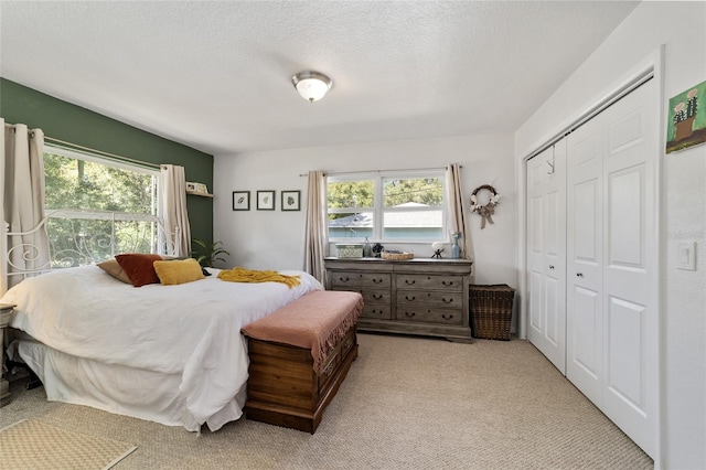 carpeted bedroom featuring a textured ceiling and a closet