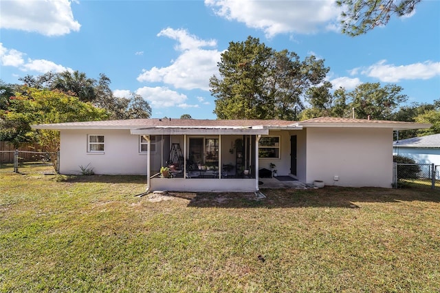 back of property with a lawn and a sunroom