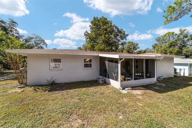 back of property with a yard and a sunroom