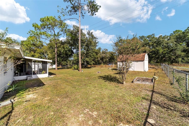 view of yard with a sunroom and a storage unit