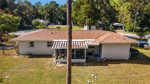 rear view of house with a sunroom and a lawn