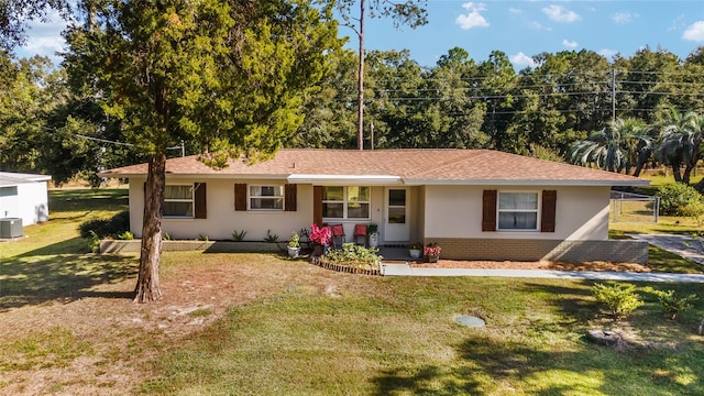 ranch-style home with covered porch, central AC, and a front lawn