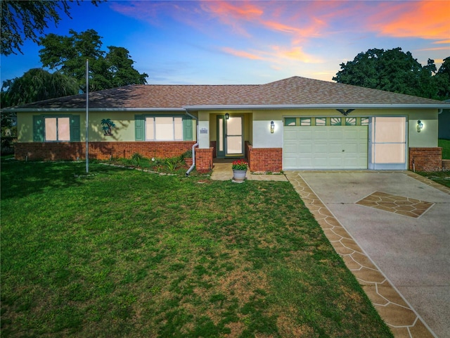 ranch-style home featuring a lawn and a garage