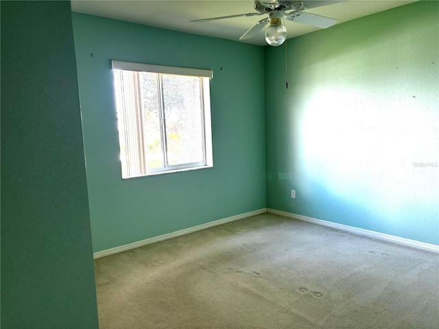 spare room featuring light carpet and ceiling fan