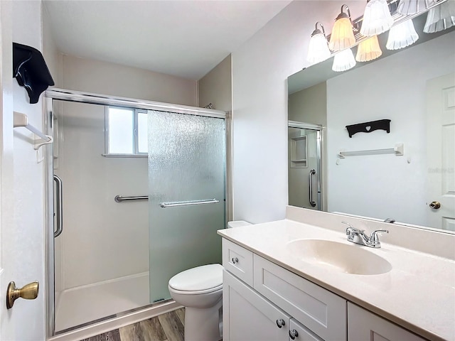 bathroom featuring an enclosed shower, vanity, toilet, and wood-type flooring