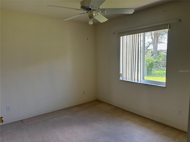 empty room featuring ceiling fan and light colored carpet