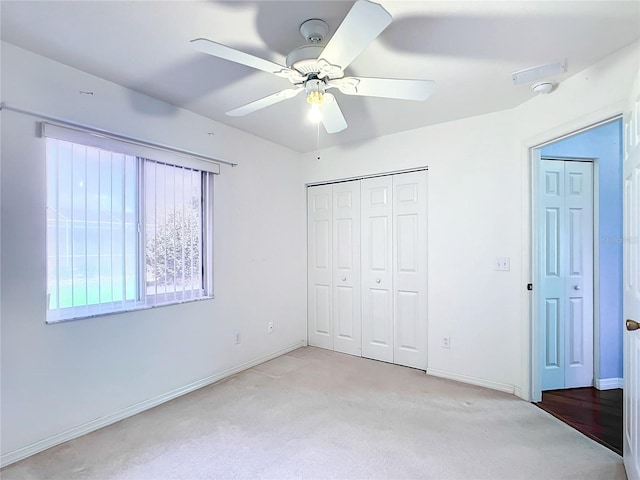 unfurnished bedroom featuring ceiling fan and light carpet